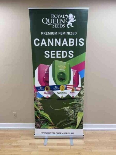 A Royal Queen Seeds Standing Banner advertising their premium feminized cannabis seeds, showcasing various seed varieties and their distinctive packaging.